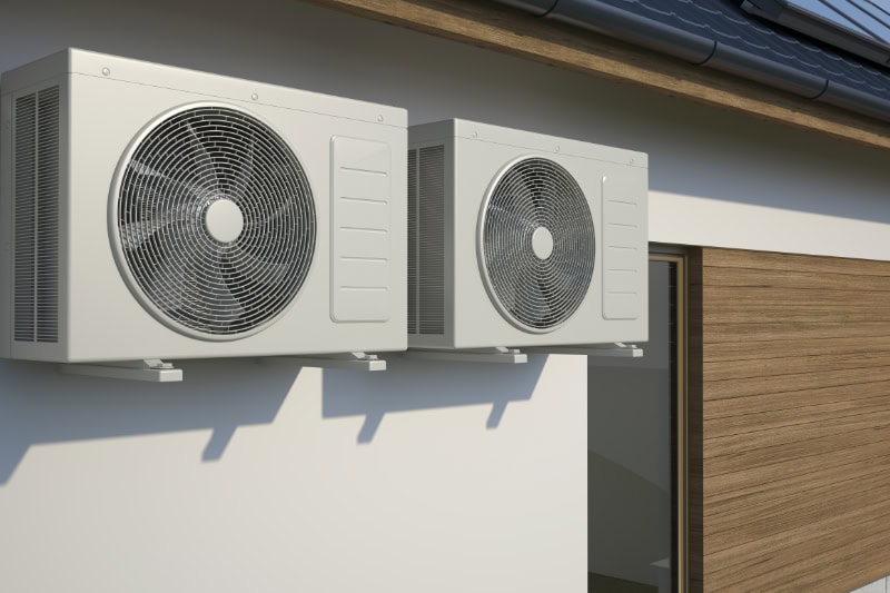 air conditioners attached to the outside of a building.