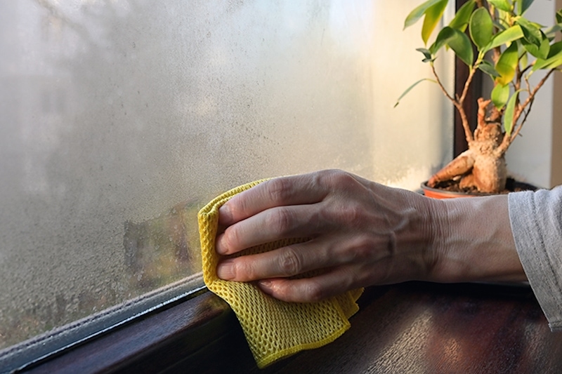 Hand wiping away condensation.