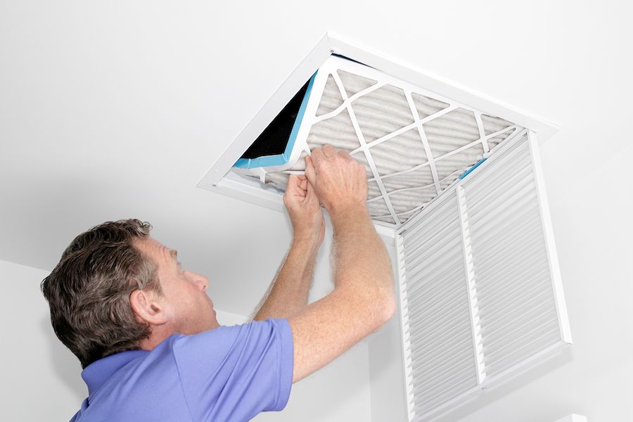 Image of someone fiddling with an air filter. What do air purifiers and air filters do?