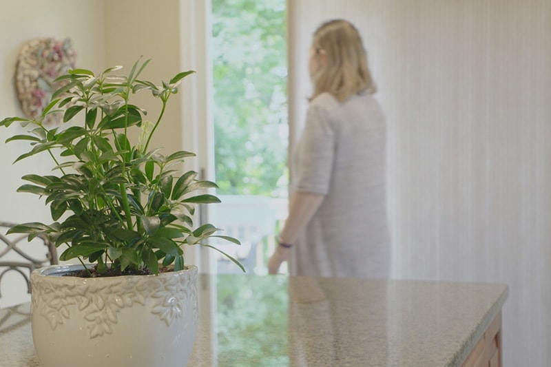 woman closing her blinds to save energy||