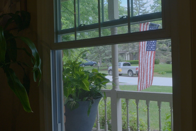 Video - Energy Saving Tip 6. Window with view of front lawn and American flag.|